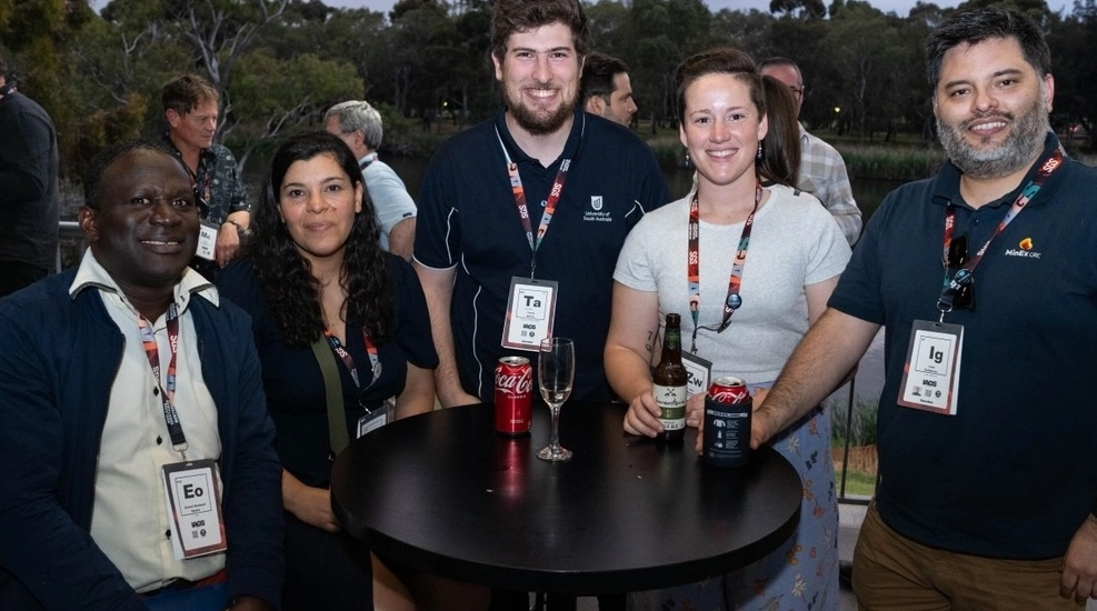 Five early-career geochemists talking together at an evening symposium social event